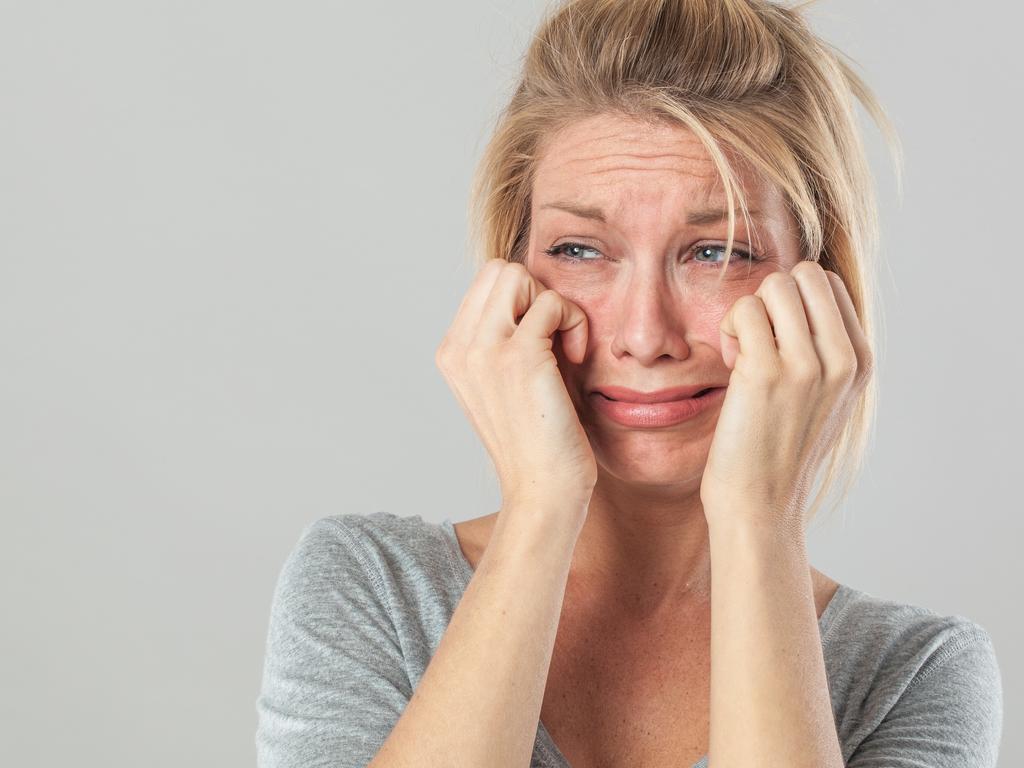 drama concept - upset young blond woman crying with big tears expressing her disappointment and sadness, grey background studio