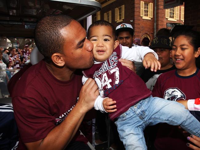 Will Hopoate gives his baby brother Devida a kiss during the Sea Eagles grand final parade after winning the 2010 title.