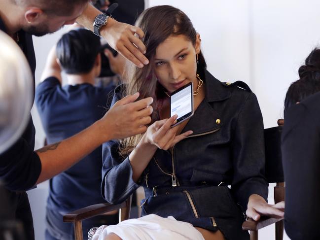 Model Bella Hadid has her hair and finger nails styled backstage before the Michael Kors Spring 2017 show. Picture: AP