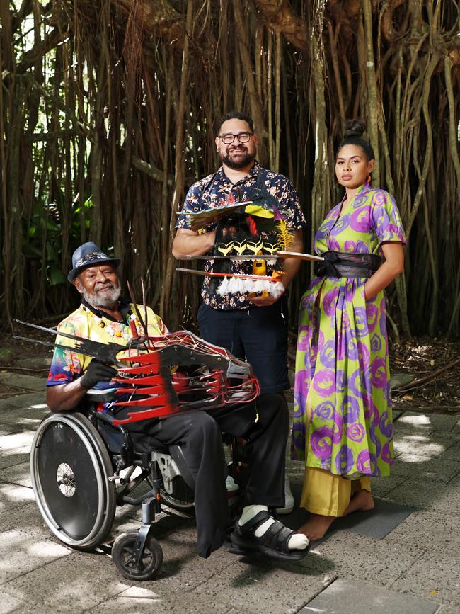 The Cairns Indigenous Art Fair will return to the Tanks Arts Centre this year, where the event was officially launched on Friday. Erub Island artist Dr Ken Thaiday Senior shows CIAF artistic director Theo Ropeyarn has world renowned Torres Strait Island headdresses, while Gillyba Ambrum models a bespoke dress by designer Lynelle Flinders. Picture: Brendan Radke