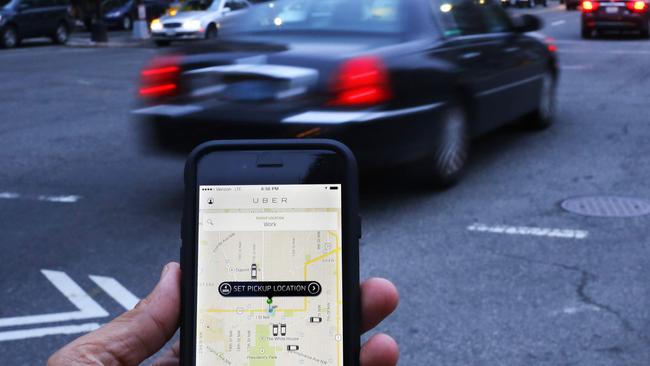 (FILES) This file photo taken on March 25, 2015 shows an UBER application being shown as cars drive by in Washington, DC. Quebec taxi drivers went to court February 2, 2016 seeking a permanent injunction banning Uber in the Canadian province, in just the latest legal challenge against the ride-sharing app in several countries.The union representing 4,000 taxi drivers in Quebec says Uber is illegal and wants it shut down locally and is also considering launching a class-action lawsuit against the startup to recover lost revenue. / AFP / Andrew Caballero-Reynolds