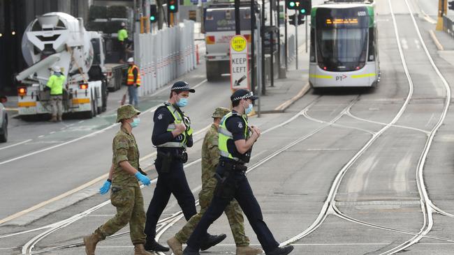 Police and ADF patrol a very quiet Docklands during stage four restrictions. Picture: David Crosling