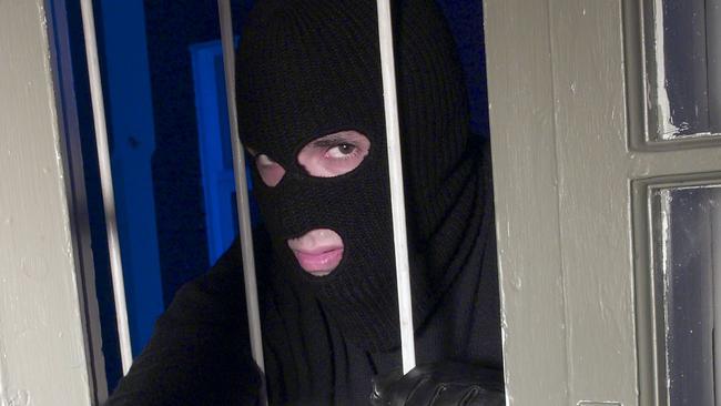 Balaklava wearing burglar climbing in window. (Pic: Thinkstock)