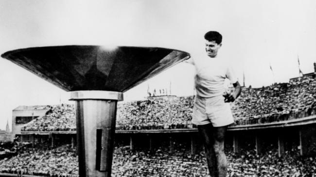 Ron Clarke lights the Olympic flame at the 1956 opening ceremony.