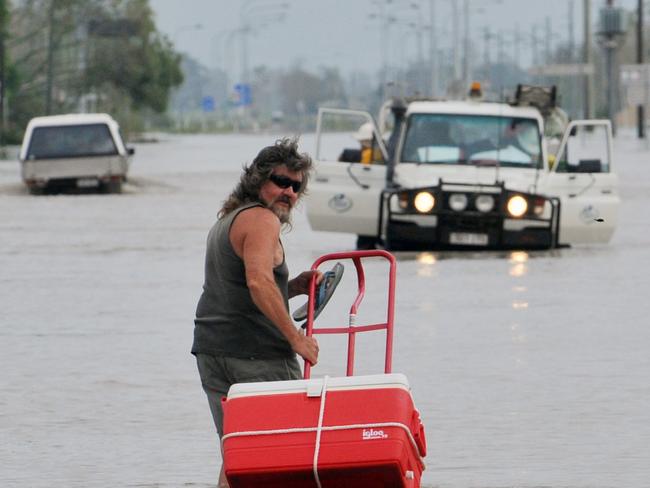 Ten year anniversary of Cyclone Yasi. Severe Cyclone Yasi 2011. In the aftermath Ingham floods. A resident wades along Townsville Road.  Picture: Evan Morgan