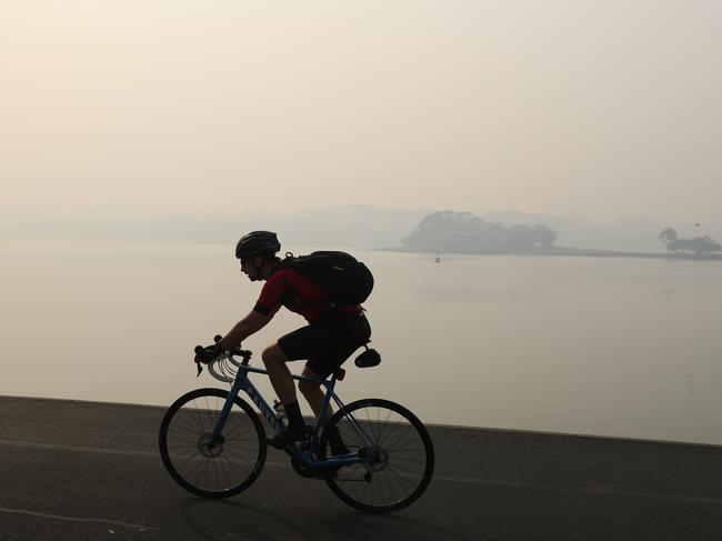 An early-morning cyclist as Sydney is blanketed with a thick haze of smoke. Picture: Rohan Kelly