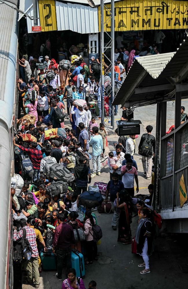 Migrants try to board an overcrowded train as they leave the city at the Jammu Tawi railway station in Jammu on May 10. Picture: Getty