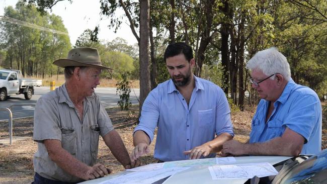 Councillor Mark Hammel (standing in the middle) with locals Geoff Rossman and Dave Collard discussing the maps for the Coomera Connector.