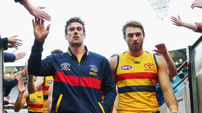 Injured Kyle Hartigan, left, limps off the MCG with fellow defender Daniel Talia. Picture: Michael Dodge (Getty Images)