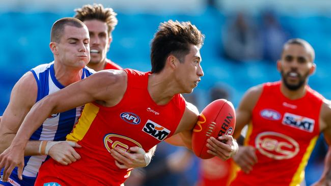 Alex Davies of the Suns is tackled by Bailey Scott of the Kangaroos during the 2023 AFL Round 24 match between the North Melbourne Kangaroos and the Gold Coast SUNS at Blundstone Arena on August 26, 2023 in Hobart, Australia. (Photo by Dylan Burns/AFL Photos via Getty Images)