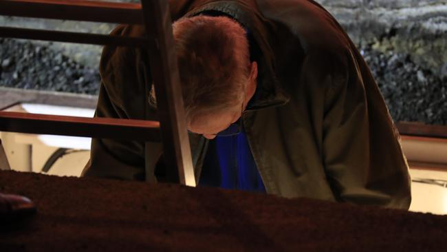 Artist Mike Parr descends to the chamber to be encased for three days beneath Hobart's Macquarie St. Picture: AAP