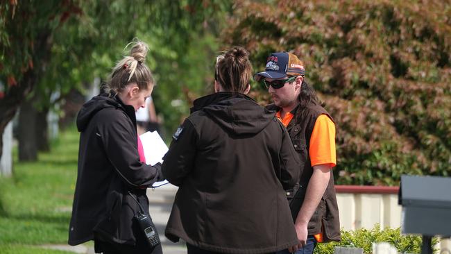 Police speaking to a neighbour after two people died after a house fire in Werribee on Saturday morning. Picture: NCA NewsWire / Luis Enrique Ascui