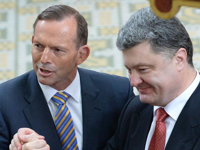 Australian Prime minister Tony Abbott and Ukraine's President Petro Poroshenko shake hands during a ecumenical church service held at Ukrainian Greek Eparchy of Saints Peter and Paul of Melbourne on Thursday, Dec. 11, 2014. Mr Poroshenko will be in the country until Friday, visiting Canberra, Sydney and Melbourne. (AAP Image/AFP Pool, Mal Fairclough) NO ARCHIVING