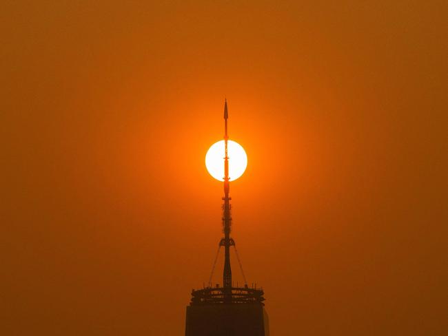 The sun rises behind the One World Trade Center in New York, while the smoke from Canada wildfires covers Manhattan. Picture: Getty Images via AFP