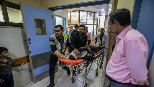 A slew of injured Palestinians rushing into the Nasser Hospital in Khan Younis following a barrage of Israeli strikes. Picture: Ahmad Hasaballah