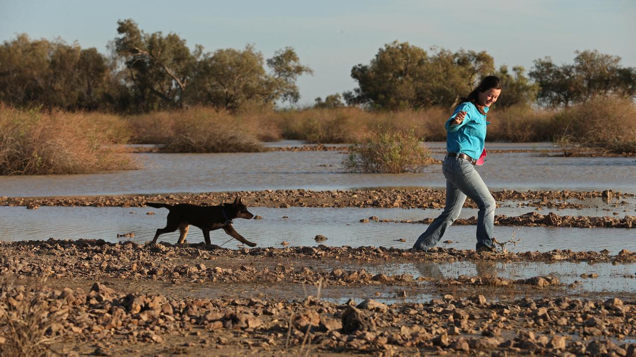 Laura Tuesley, 22, left, greets the floodwater at Warburton Creek. Picture: Lyndon Mechielsen