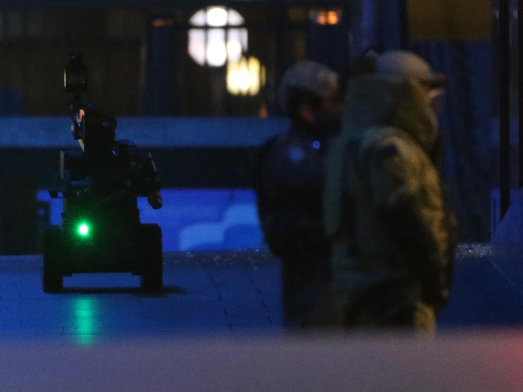 A police bomb squad bomb disposal robot top left, moves into place during a cafe siege in the central business district of Sydney. Picture: Glenn Nicholls (AP)