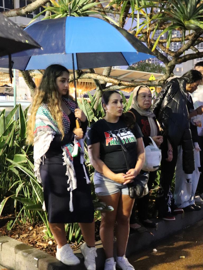 Protesters gathered at Surfers Paradise Esplanade despite torrential rain to call for an immediate ceasefire of bombing in the Gaza Strip. Picture: Amaani Siddeek