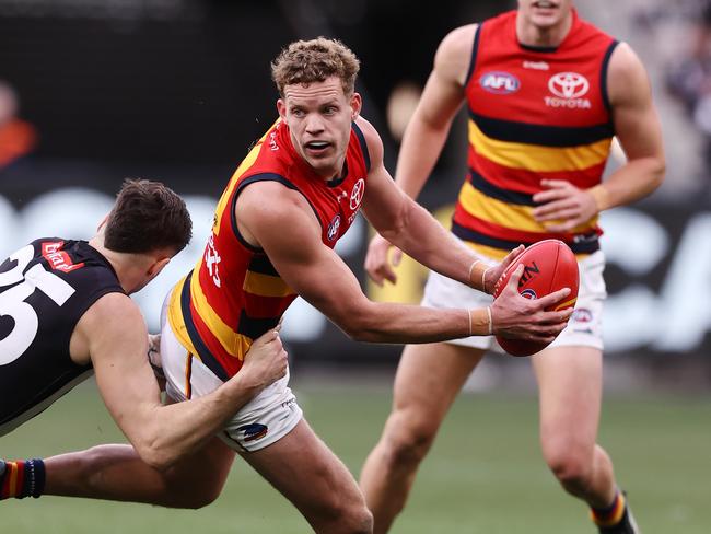 MELBOURNE - June 25 : AFL.   Mitchell Hinge of the Crows looks to give as he is tackled by Jack Crisp of the Magpies  during the round 15  AFL match between Collingwood and Adelaide at the MCG on June 25, 2023, in Melbourne.  Photo by Michael Klein.