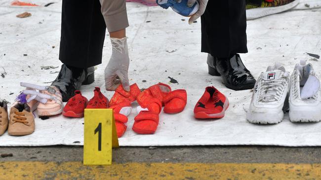 A policewoman displays shoes, recovered during search operations, from passengers on-board the ill-fated Lion Air flight JT 610 in Jakarta. Picture: AFP