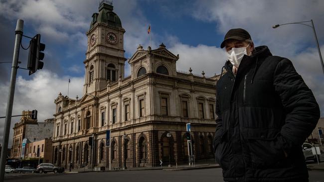 A man wearing a mask walks across a quiet Sturt Street in Ballarat. Picture: Getty