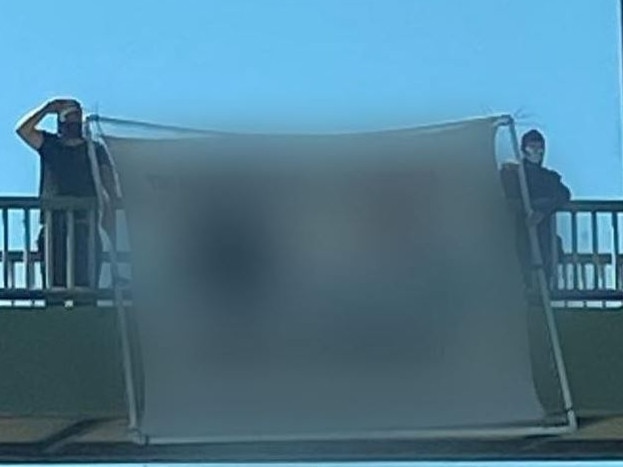 Men flying an offensive banner on the M1 at Helensvale in November last year. Picture: Supplied