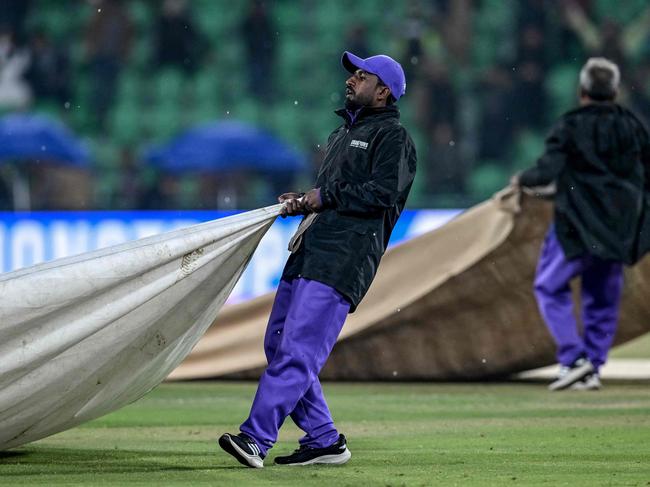 Groundmen cover the pitch as rain stops play during the ICC Champions Trophy one-day international (ODI) cricket match between Australia and Afghanistan at the Gaddafi Stadium in Lahore. Picture: Aamir QURESHI / AFP