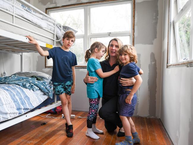 Courtney O'Brien with her five-year-old twins and seven -year-old son inside their flood impacted home in Lismore. The family has received help from the Two Rooms project which aims to install gyprock into 2 rooms in flood impacted homes to insulate against the weather. Picture: Cath Piltz