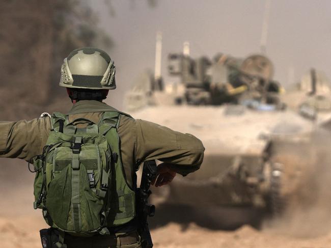 --PHOTO TAKEN DURING A CONTROLLED TOUR AND SUBSEQUENTLY EDITED UNDER THE SUPERVISION OF THE ISRAELI MILITARYâ Israeli troops are pictured near the border fence between Israel and the Gaza Strip ahead of an operation in the north of the Palestinian enclave on November 8, 2023, amid continuing battles between Israel and the Palestinian militant group Hamas. (Photo by DaphnÃ© LEMELIN / AFP)