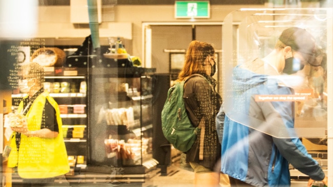 Shoppers in face masks are seen at a Woolworths self-serve checkout. Photo: Jenny Evans/Getty Images