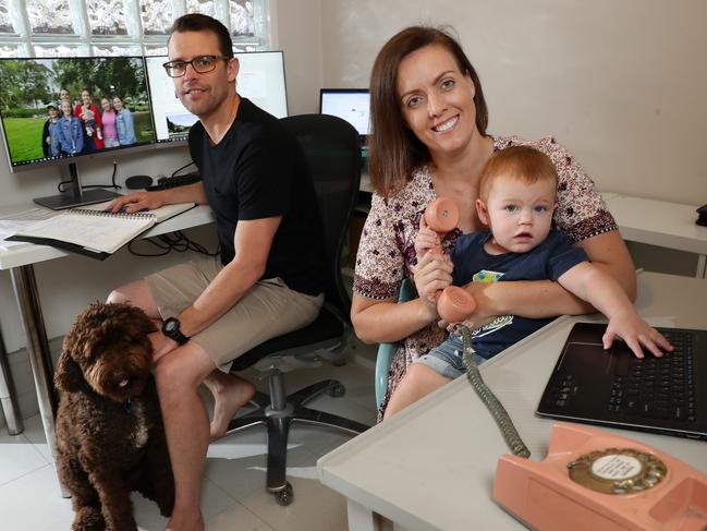 Mark Hall, 41, and Belinda Roud-Hall, 34, working from their home office with son Theodore, 1, and dog Hendrix. Picture: Liam Kidston