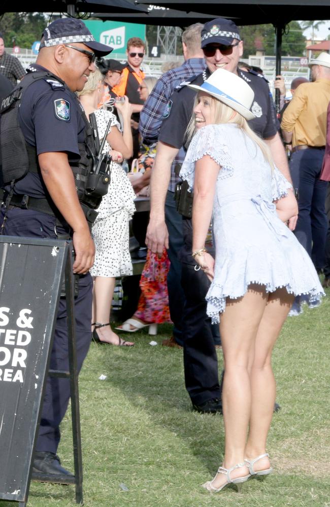 Be kind to your local friendly police officers on the day, as this punter was doing at Eagle Farm’s Cup celebrations in 2021. Picture: Steve Pohlner