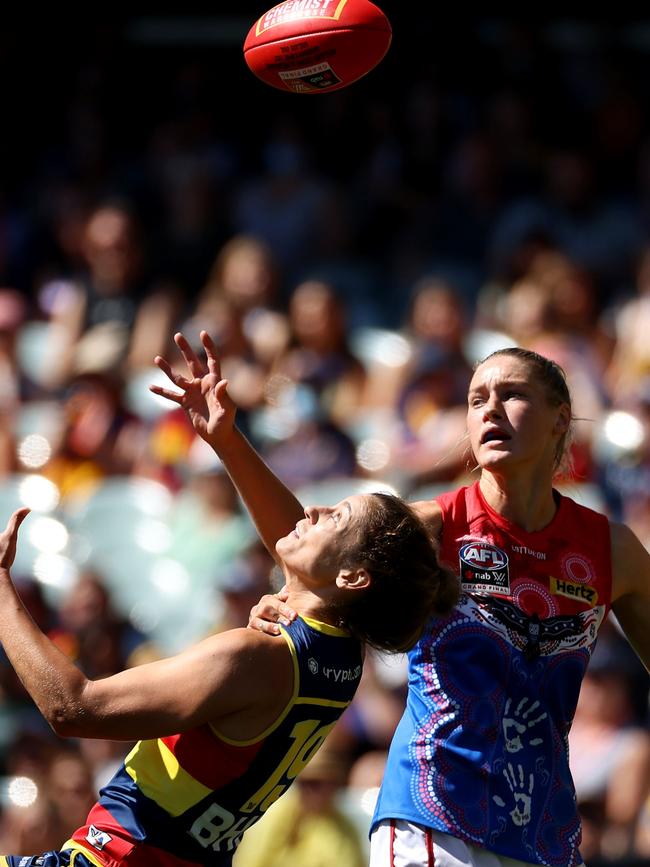 Jasmyn Hewett keeps her eyes on the ball as she is brought to ground in a tackle.