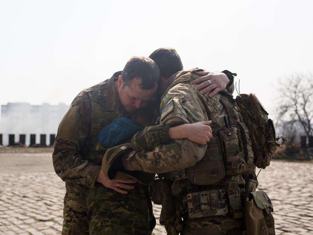 Ukrainian servicemen comfort Daniil, 12, the son of Vladyslav Buvalkin, 42, who died in action and was buried on March 23, 2022 in Kyiv, Ukraine. Picture: Getty Images