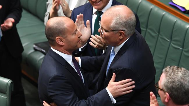 Treasurer Josh Frydenberg and Prime Minister Scott Morrison embrace following the delivery of the budget in the House of Representatives. Picture: Getty Images