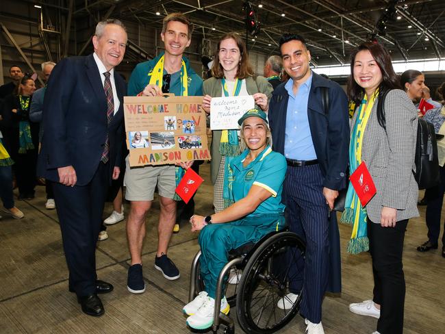 Paralympian and flag-bearer Madison De Rozario is welcomed home from Paris by Bill Shorten, her physio Ned Brophy-Williams and friends. Picture: NewsWire/Gaye Gerard