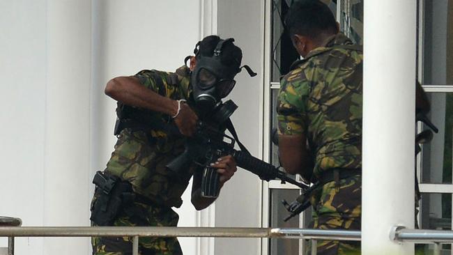 Sri Lankan Special Task Force (STF) personnel in gas masks are pictured outside a house during a raid after a suicide blast had killed police searching the property. Picture: AFP