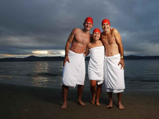 Dave Abrey of Brisbane, Sabrina Carter of Launceston, Glen Harvey of Sydney who became friends after meeting on the beach during the solstice swim one year and now meet up each year to do the swim together.  Dark Mofo Nude Solstice Swim 2024 at Long Beach Sandy Bay.  Picture: Nikki Davis-Jones