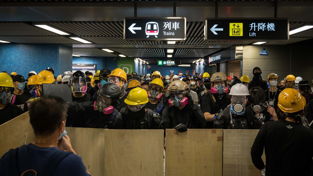 Protesters with makeshift shields pass through a subway station on their way to a police station in the Kwun Tong district. Picture: Getty Images