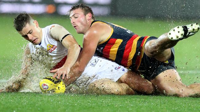 Daniel Talia makes a desperate attempt to prise the ball from Bulldog Josh Dunkley in the wet at Adelaide Ova on Friday. Picture: AAP Image/Kelly Barnes