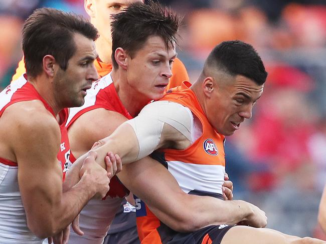 Giants Dylan Shiel kicks being tackled by Sydney's Callum Sinclair during the AFL Sydney Derby match between the GWS Giants and Sydney Swans at Spotless Stadium. Picture. Phil Hillyard