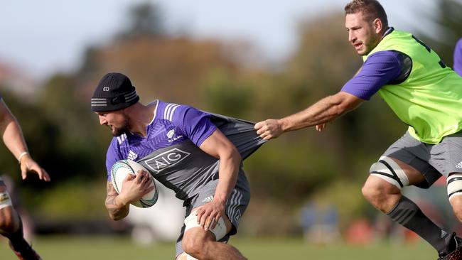 Elliot Dixon of the All Blacks is held back by Luke Romano during a training session.