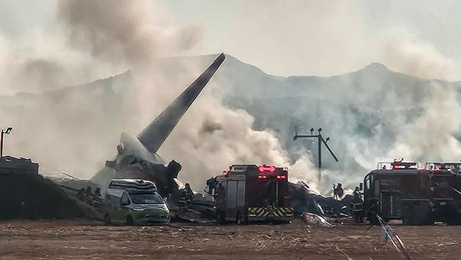 Smoke rises from the tail section of a Jeju Air Boeing 737-800 planet after it crashed and burst into flames at Muan International Airport in South Korea on Sunday. Picture: AFP