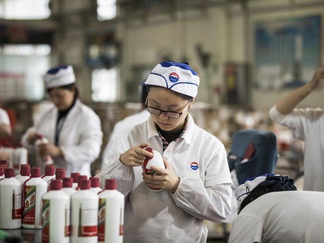 An employee inspects bottles of baijiu on the production line at the Kweichow Moutai factory in Renhuai, Guizhou province, China. PHOTO: QILAI SHEN