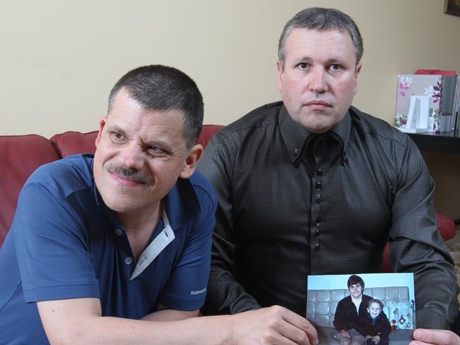 Adam James (left) and his brother Mark James with a picture of their murdered mother Maria James. Picture: Scott Chris