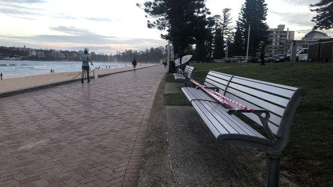 Benches along Manly seafront taped up due to COVID-19 social distancing rules. Picture: Julie Cross