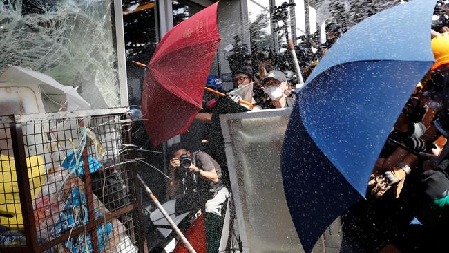 Riot police use pepper spray as protesters try to break into the Legislative Council building. Picture: Reuters