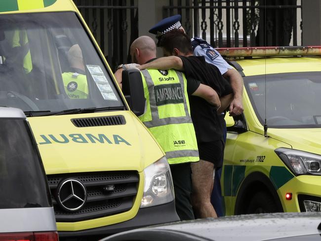 Police and ambulance staff help a wounded man from outside a mosque in central Christchurch. Picture: AP