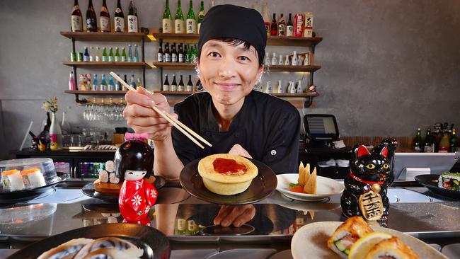 Won Min Lee of Ganbare Kaz Kaiten Sushi restaurant in Chapel St, Windsor, with a Four’N Twenty pie, which will be available in Japan from today. Picture: Nicki Connolly