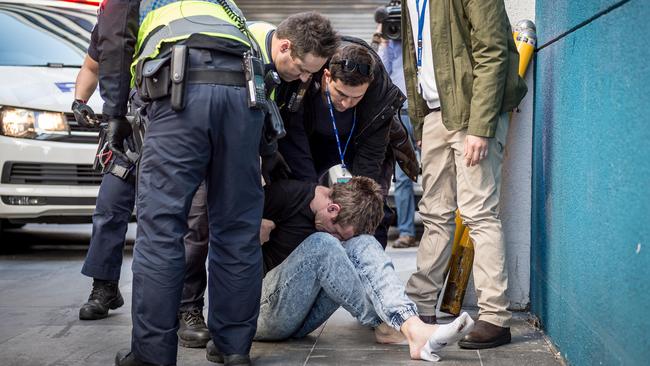 A man is taken into police custody after a police pursuit in the city. Picture: Jake Nowakowski